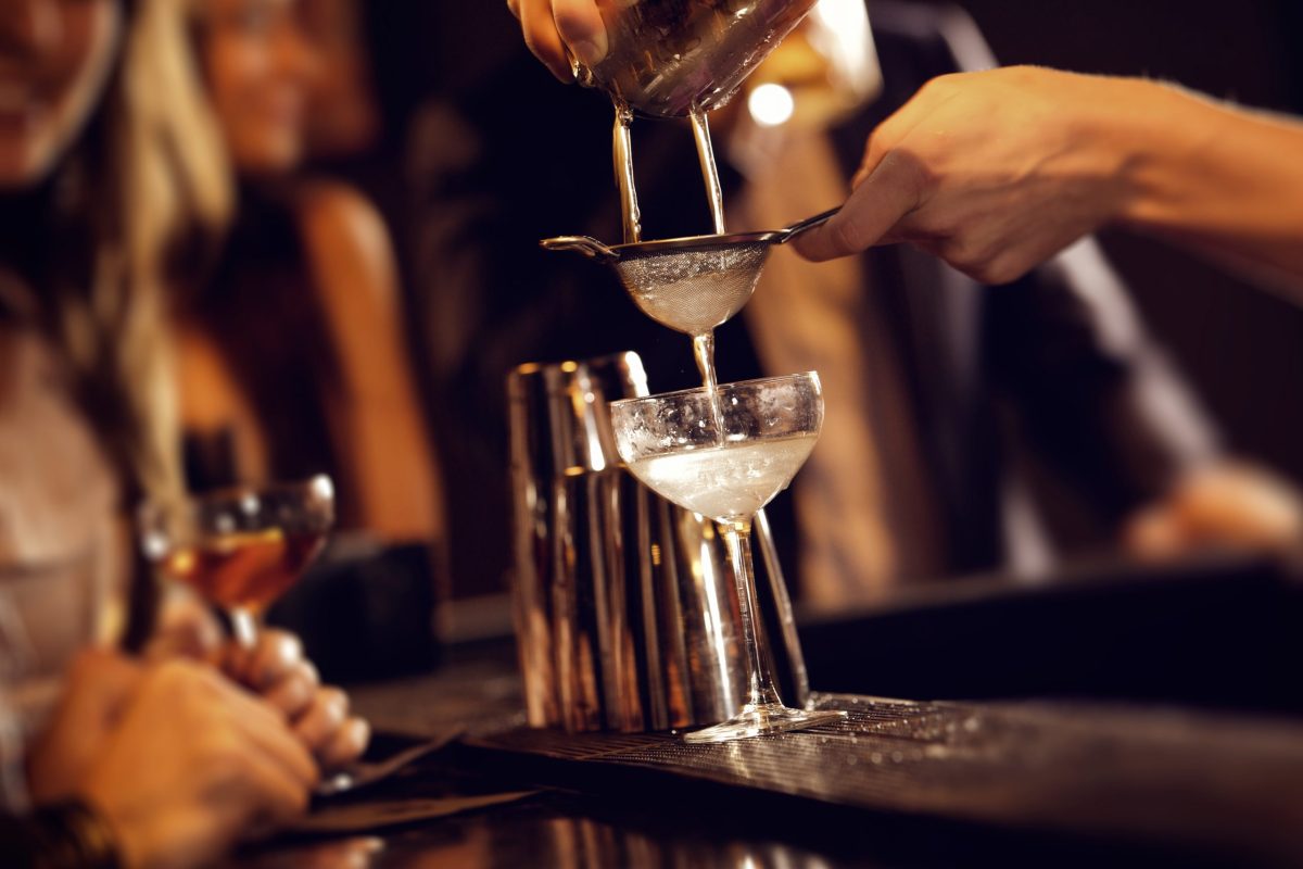 Barman pouring wine from shaker and serving it